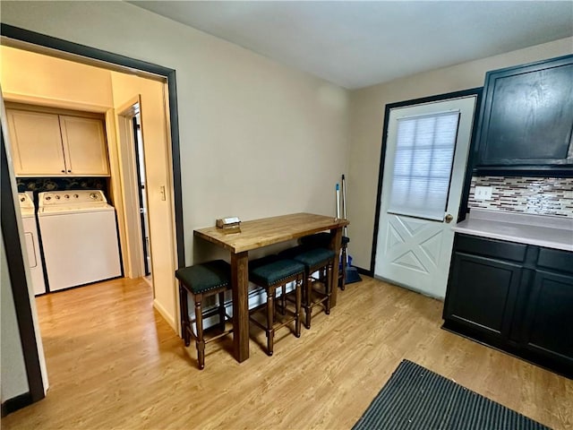 dining area featuring light wood-style floors, independent washer and dryer, and baseboards