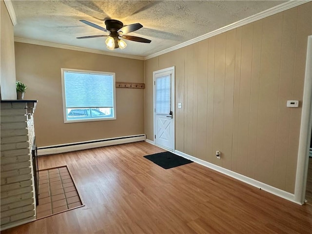 entrance foyer with a baseboard heating unit, crown molding, a textured ceiling, and light wood finished floors