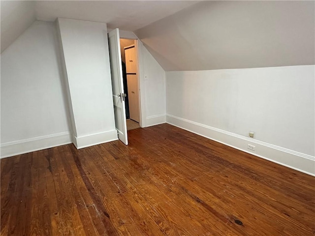 bonus room with lofted ceiling, dark wood-style floors, and baseboards