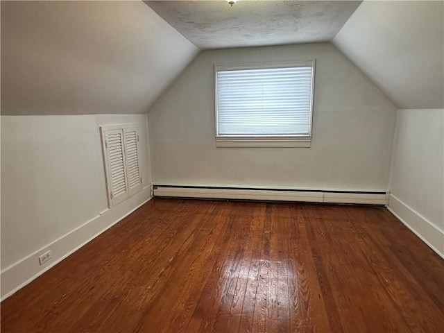 bonus room with baseboard heating, baseboards, vaulted ceiling, and dark wood-style flooring