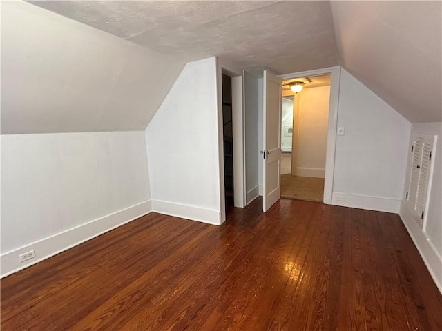 bonus room featuring lofted ceiling, baseboards, and dark wood-style flooring