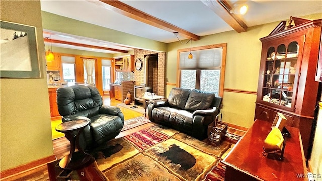 living room with baseboards, beam ceiling, and wood finished floors