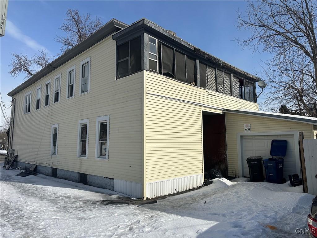 snow covered property with a garage