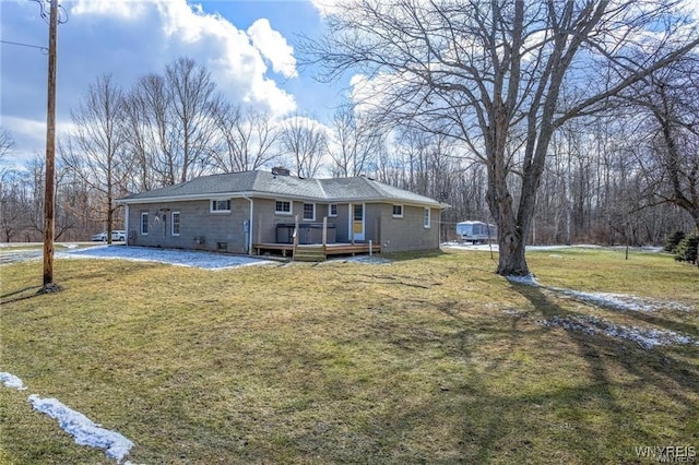 view of front facade featuring a front lawn, a chimney, and a wooden deck