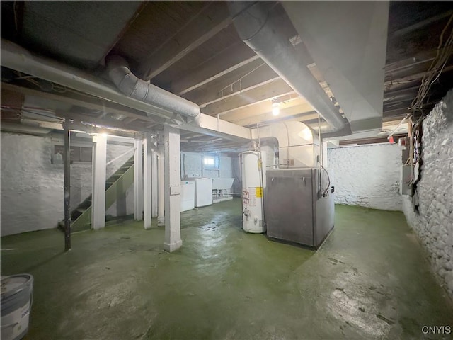 basement with gas water heater, heating unit, and washer and dryer