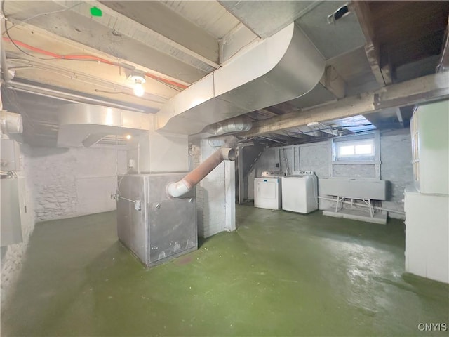 basement with washing machine and clothes dryer and heating unit