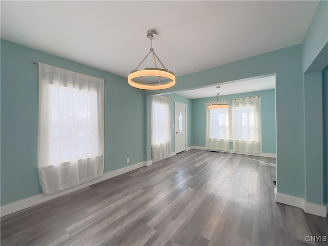 unfurnished room with baseboards and wood finished floors