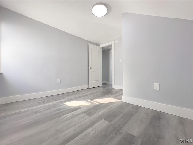 unfurnished room featuring light wood-style flooring and baseboards