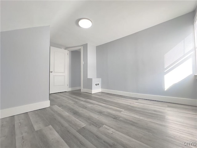 interior space with visible vents, light wood-style flooring, and baseboards