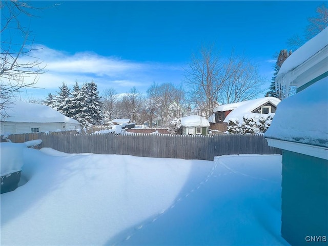 yard layered in snow featuring fence