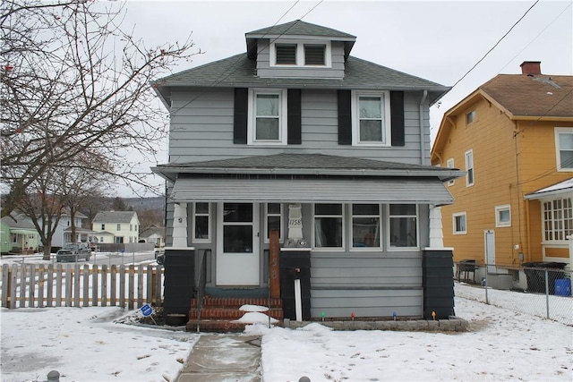 american foursquare style home featuring entry steps, fence, and roof with shingles