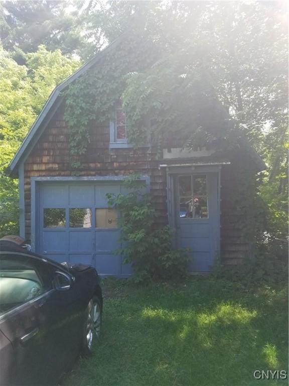 view of front of home with a garage and an outbuilding