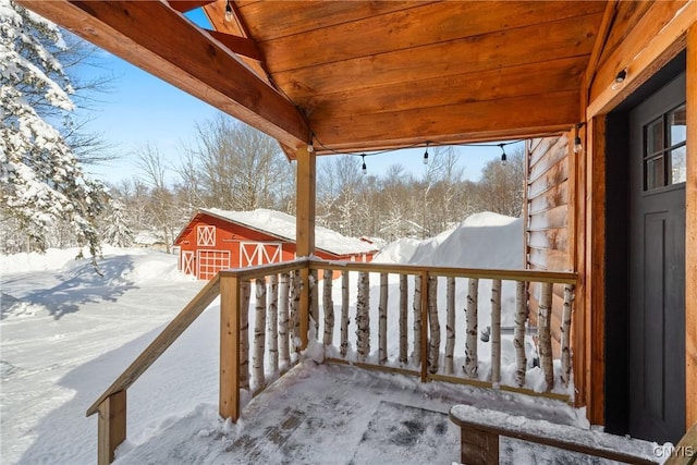 snow covered deck featuring an outbuilding