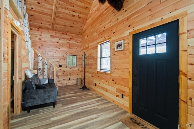 entrance foyer with lofted ceiling, wood ceiling, wooden walls, and wood finished floors