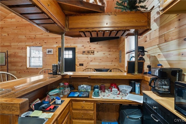 kitchen with brown cabinetry and wood walls