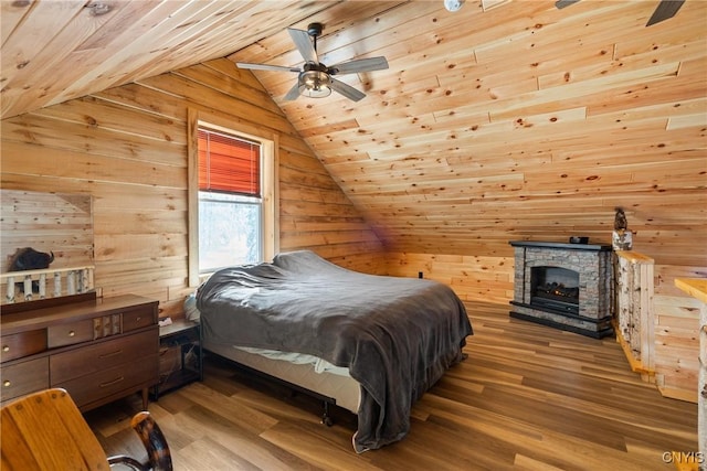 bedroom featuring lofted ceiling, a stone fireplace, wooden walls, wood finished floors, and wooden ceiling