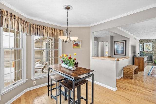 dining room featuring ornamental molding, light wood-type flooring, an inviting chandelier, and baseboards