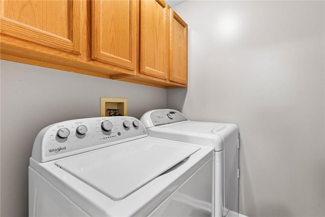 washroom featuring cabinet space and separate washer and dryer