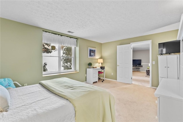 bedroom featuring a textured ceiling, carpet flooring, visible vents, and baseboards