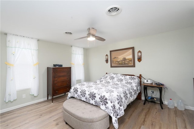 bedroom with light wood finished floors, baseboards, and visible vents