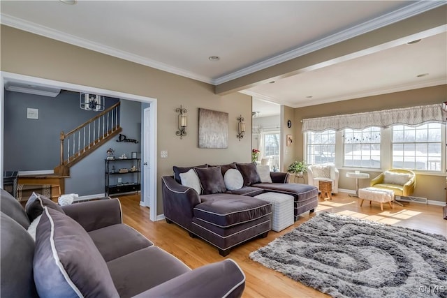 living room featuring baseboards, light wood finished floors, stairway, and crown molding