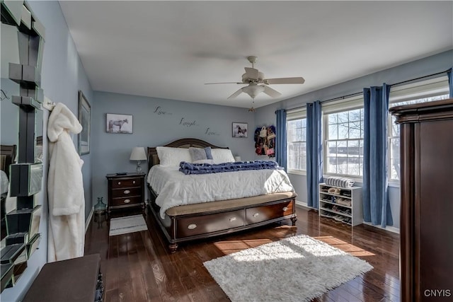 bedroom with a ceiling fan, baseboards, and dark wood-type flooring