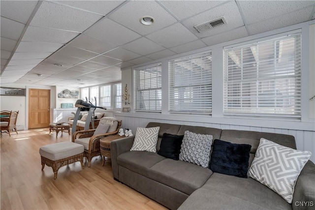 living room featuring a paneled ceiling, light wood-style flooring, and visible vents