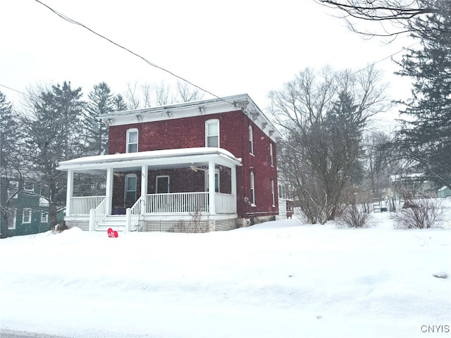 italianate house featuring a porch and brick siding