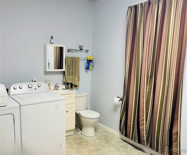 bathroom with toilet, baseboards, washer and clothes dryer, and vanity