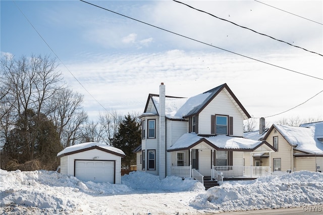 victorian home with covered porch, a chimney, an outbuilding, and a garage