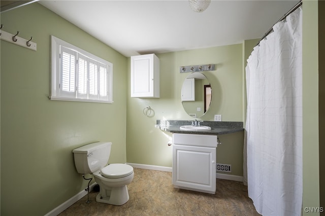 bathroom with baseboards, vanity, and toilet