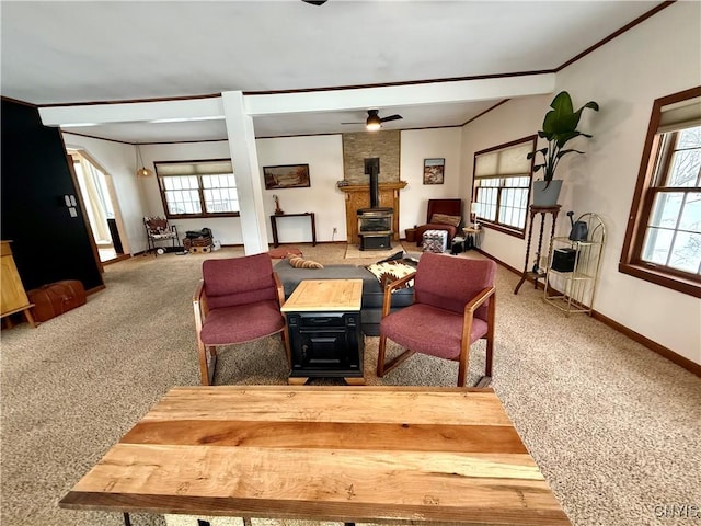 carpeted dining space featuring a wealth of natural light, a wood stove, and baseboards