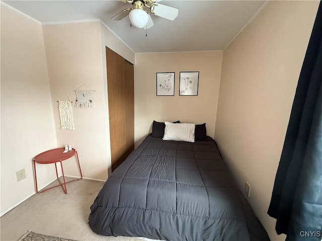 carpeted bedroom featuring crown molding and ceiling fan