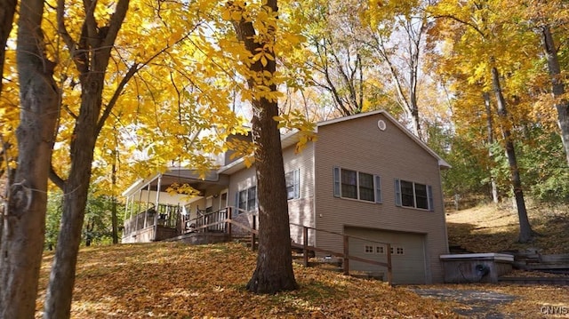 view of side of home featuring a garage and covered porch