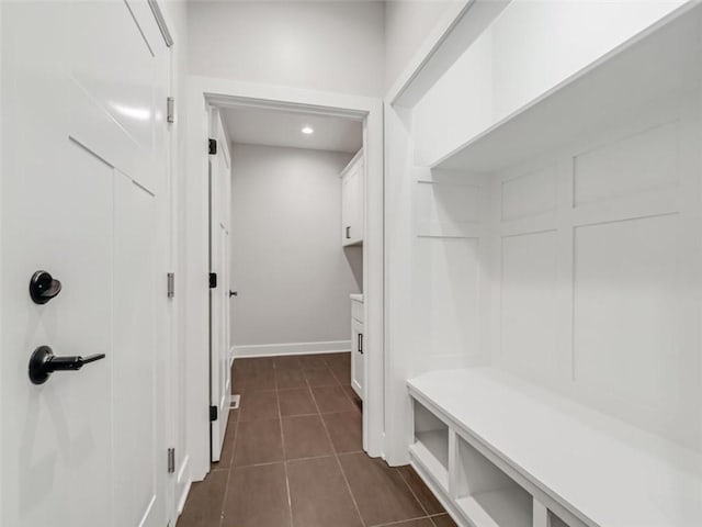 mudroom featuring dark tile patterned floors and baseboards