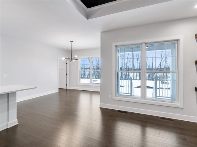 interior space with dark wood finished floors, baseboards, and an inviting chandelier