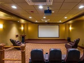 cinema room featuring a paneled ceiling and baseboards