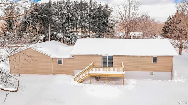 snow covered property featuring a wooden deck and stairs