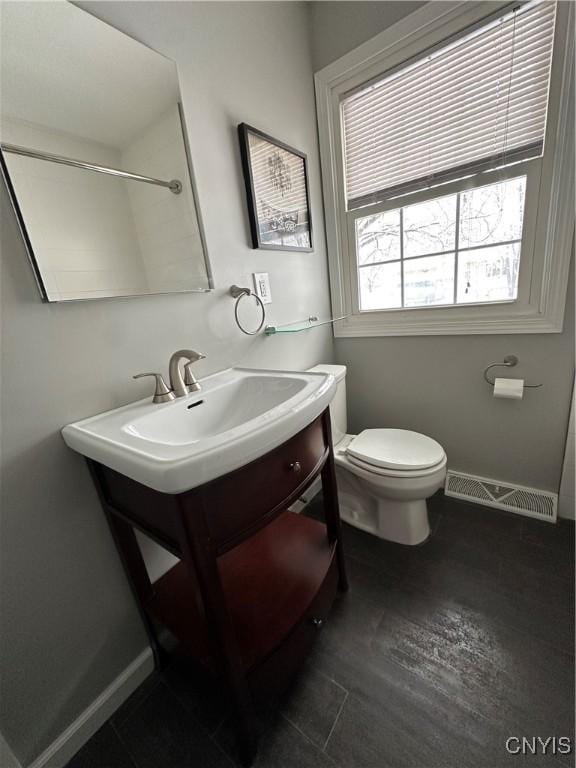 bathroom with toilet, visible vents, baseboards, and vanity