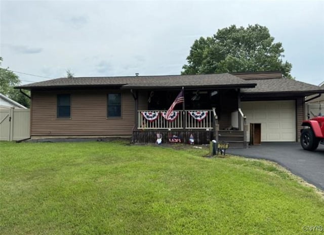 ranch-style home with a garage, aphalt driveway, and a front yard