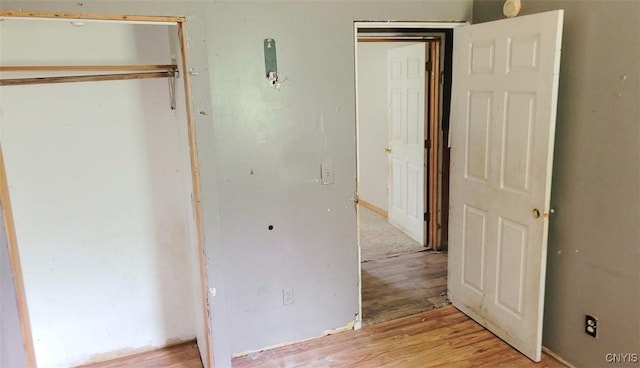 unfurnished bedroom featuring a closet and light wood finished floors