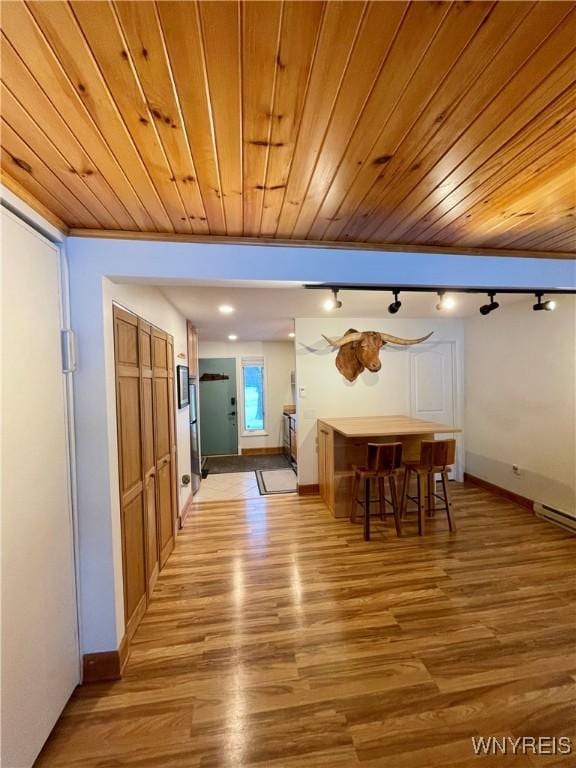 unfurnished dining area featuring track lighting, wooden ceiling, and light wood-style floors