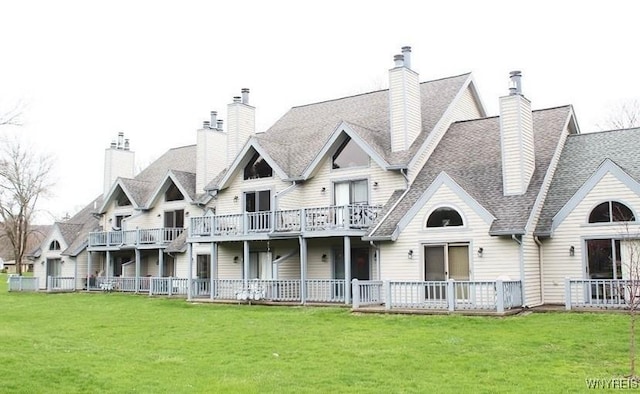 view of front of property featuring roof with shingles, fence, and a front lawn