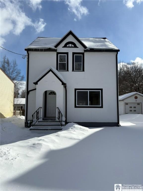 traditional-style house featuring entry steps and an outdoor structure