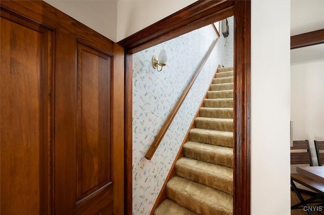 stairs featuring wallpapered walls