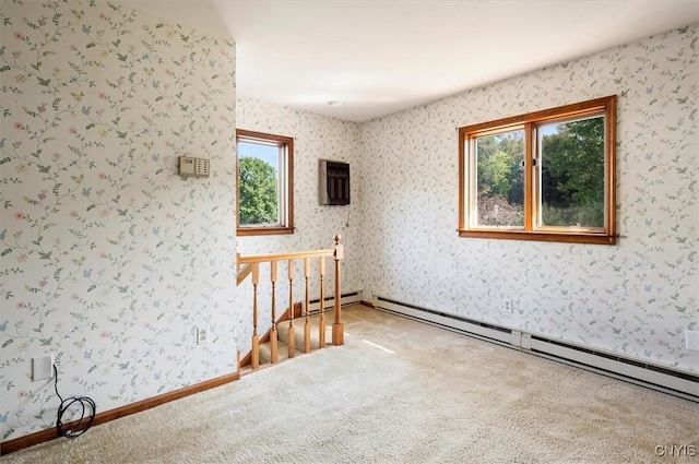 carpeted spare room featuring a wall unit AC, baseboard heating, and wallpapered walls