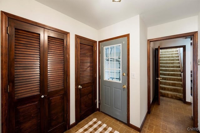 foyer entrance with baseboards and stairs