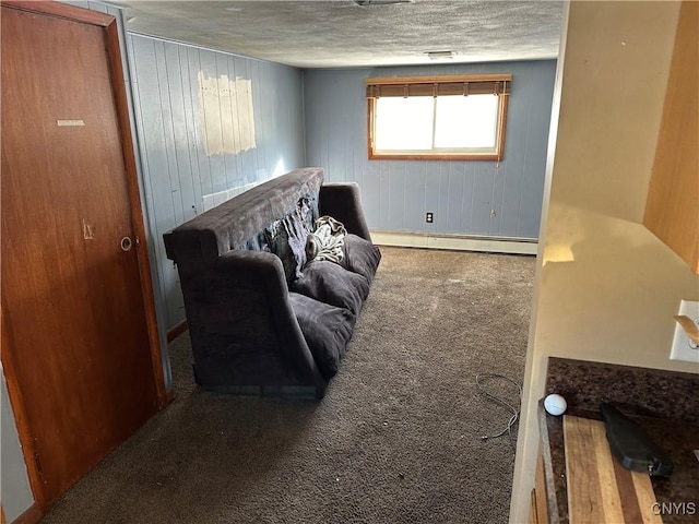 carpeted living room with a baseboard heating unit and a textured ceiling