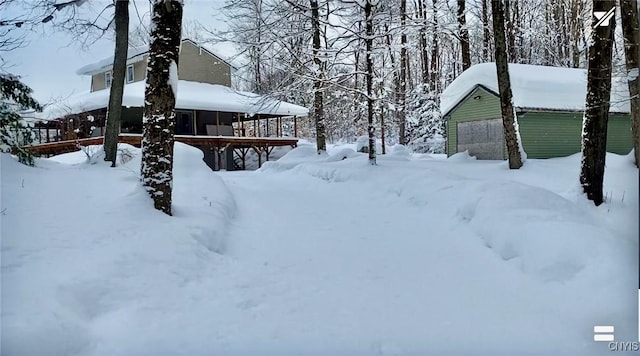 snowy yard featuring an outbuilding