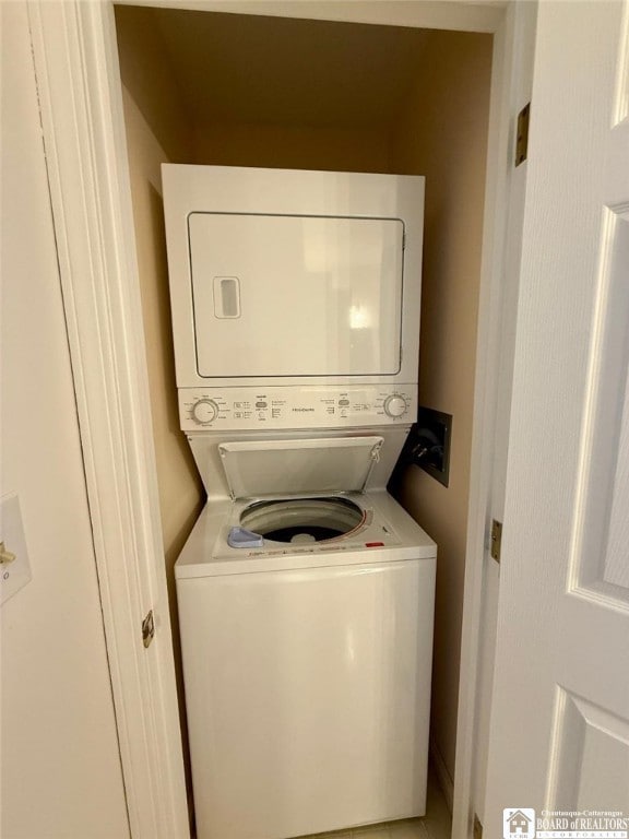 laundry room featuring stacked washer / dryer and laundry area